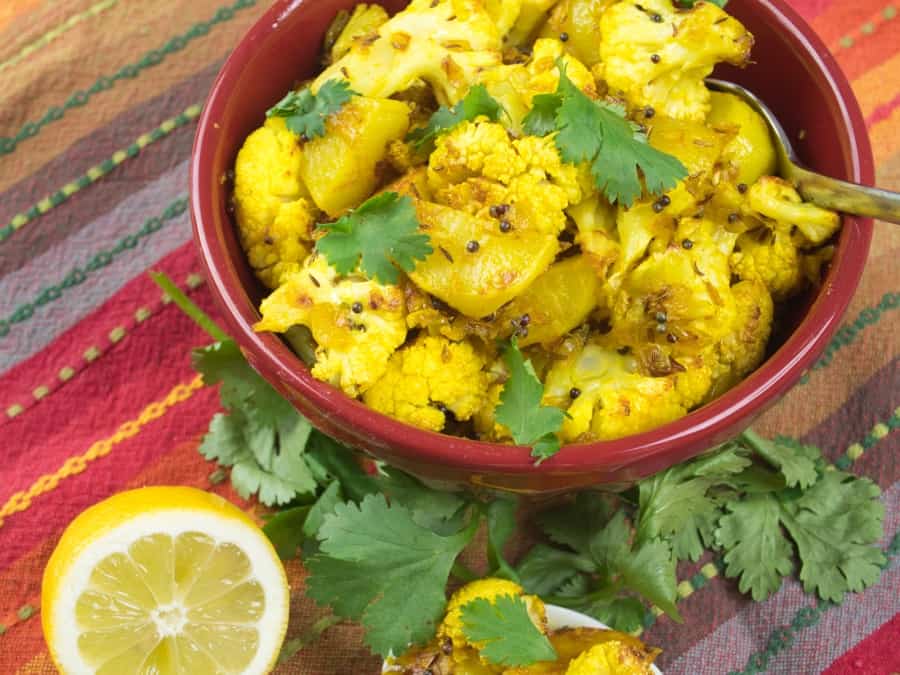 Cauliflower Potato Curry (Aloo Gobi) -- vegetable curry in a large serving bowl with a flutter of cilantro