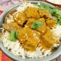 Served on a bed of fluffy basmati rice, garnished with fresh cilantro leaves.