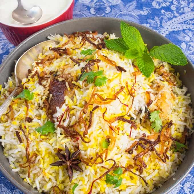 Easy, Enticing Chicken Biryani served up in a large grey ceramic serving dish graced with crispy brown onions, star anise and red saffron.