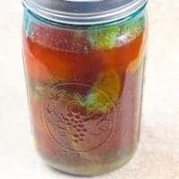 Lemon Pickle Recipe (Nimbu ka Achar) Lime and lemon wedges mixed with spices and covered with oil and ready for a rest in a dark place.