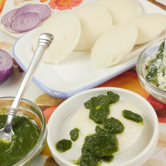 Homemade Idli Recipe Served with dribbles of cilantro chutney.