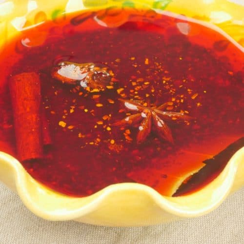 Homemade Sichuan Chili oil Small bowl of Sichuan chili oil gilded with whole star anise, bay leaves and cinnamon sticks.