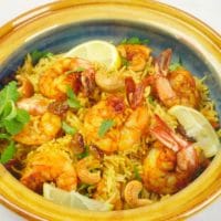 Instant Pot Shrimp Biryani (Kerala-StyInstant Pot Shrimp Biryani (Kerala-Style) Shrimp biryani ready to be served in a pretty pot dressed with slices of lemon, topped with toasted cashews and raisins, and a dusting of fresh herbs.