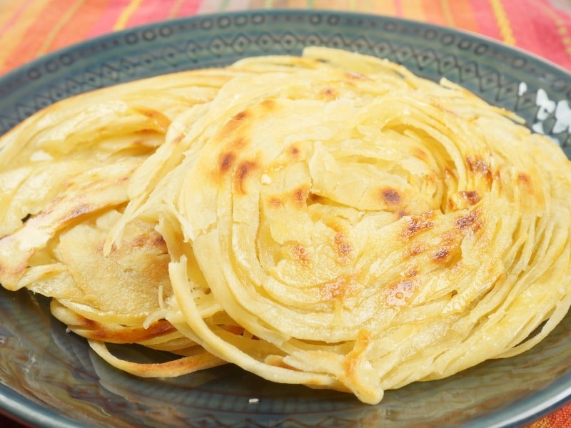 Layered Indian Flatbread (Kerala Parotta) Stacked on a pretty plate ready to be devoured.