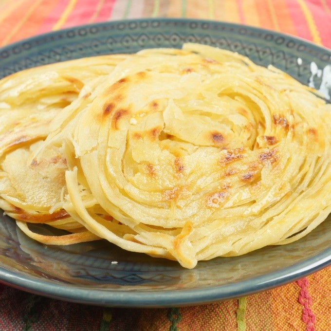 Layered Indian Flatbread (Kerala Parotta) Stacked on a pretty plate ready to be devoured.