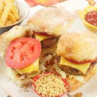 Mini burgers all dressed up with tomatoes, cheese, sev and masala chips.