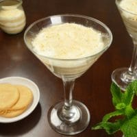 Layered puddings served with whole Marie biscuits and a small bouquet of mint.