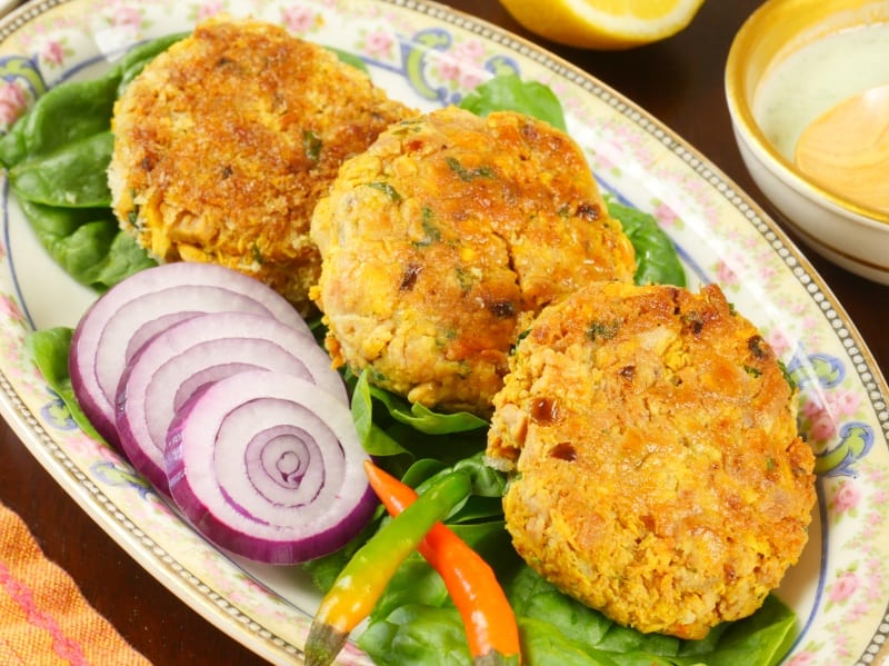 Fish Patties Goan-Style Served on a bed of greens and red onion slices.