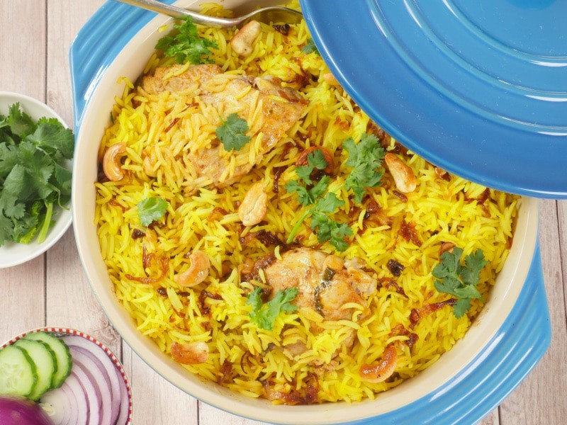 Goan Chicken Biryani has been cooked, garnished with toasted cashews, crispy brown onions, and a show of cilantro.