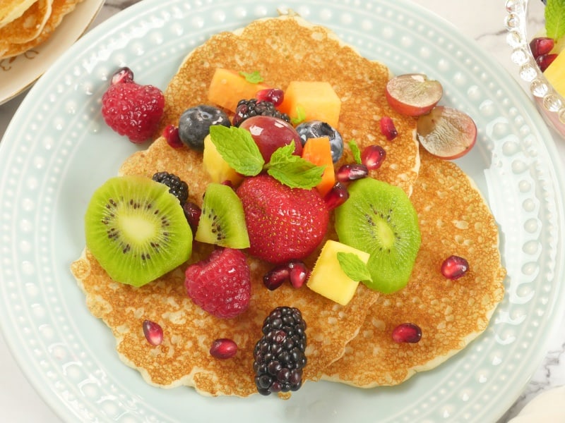 Rice Pancakes (Indian-style) ~ Three rice pancakes served with fruit salad and a flurry of mint leaves.