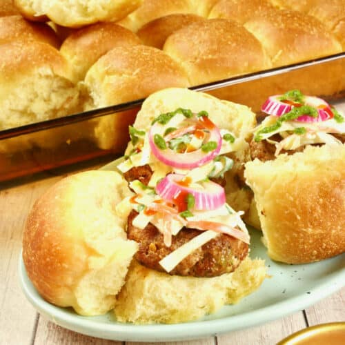 Made into cute little sliders topped with a slaw, pickled red onions, and a drizzle of red and green chutneys.