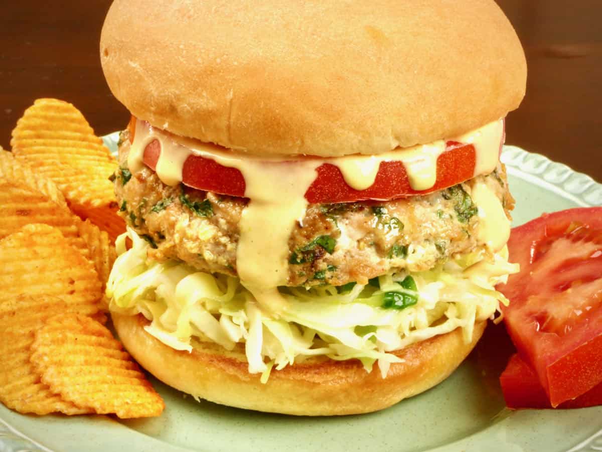 Burgers served on a bun with spicy potato chips, tomato, coleslaw and special sauce.