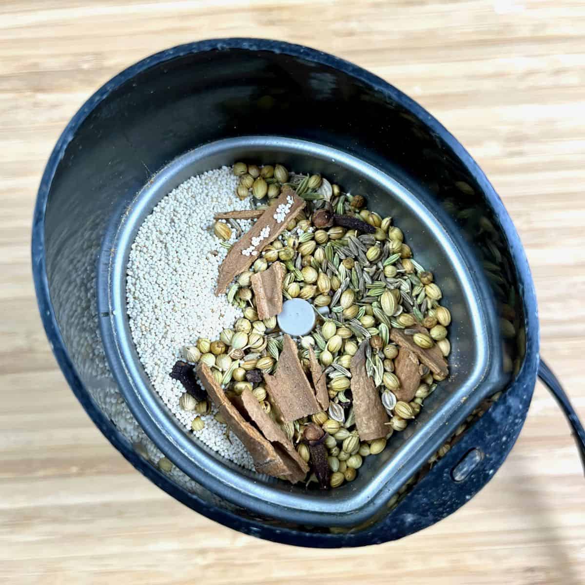 Whole toasted spices for Coconut Lamb Curry marinade in a spice grinder