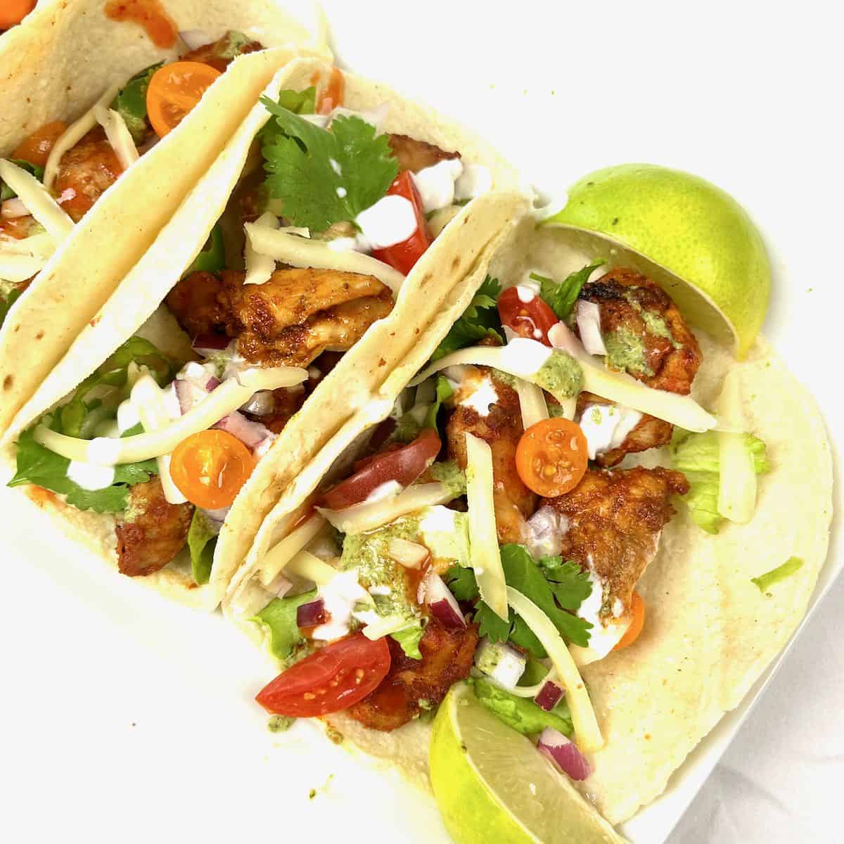 Chicken Tikka Tacos served up with wedges of lime