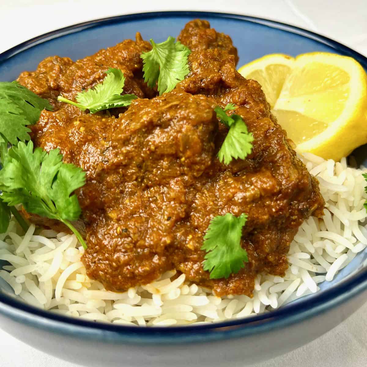 Easy Lamb Vindaloo served on a bed of steamed basmati rice with a wedge of lemon